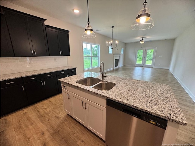 364 Whitestone Dr, Fayetteville, NC 28312 - kitchen with stainless steel dishwasher, dark cabinetry, light wood finished floors, hanging light fixtures, and recessed lighting