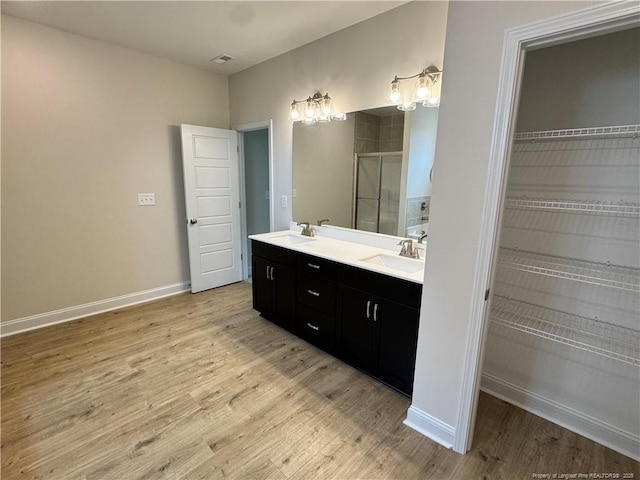 364 Whitestone Dr, Fayetteville, NC 28312 - bathroom featuring a shower stall, double vanity, wood finished floors, and a spacious closet