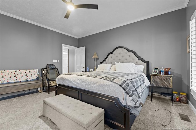 bedroom with carpet floors, a ceiling fan, visible vents, and crown molding