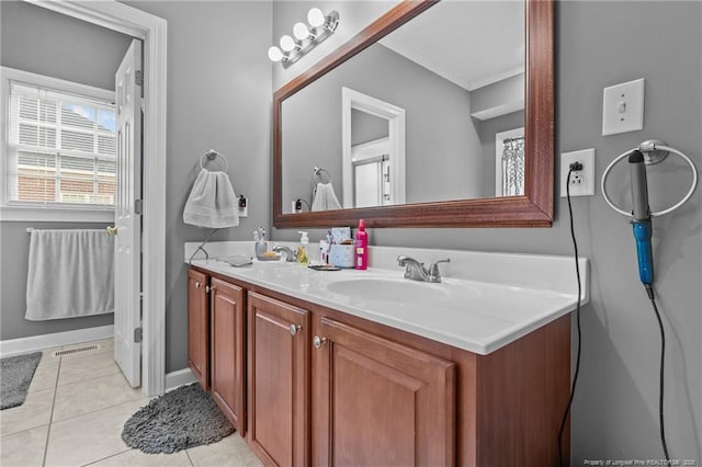 full bath featuring double vanity, visible vents, a sink, tile patterned flooring, and baseboards