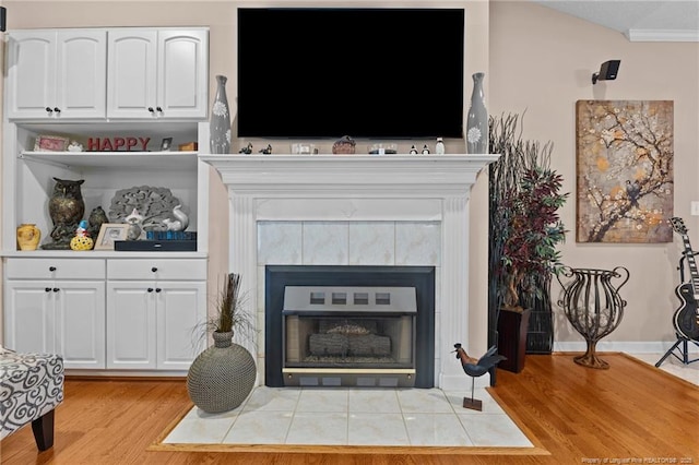 interior details featuring a fireplace, baseboards, and wood finished floors