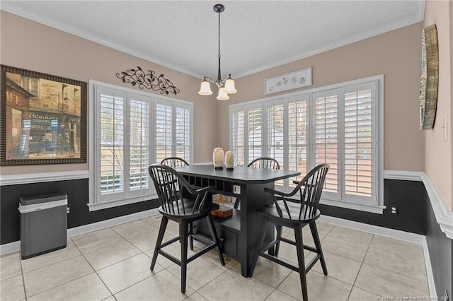 dining room with light tile patterned floors, baseboards, ornamental molding, and a notable chandelier