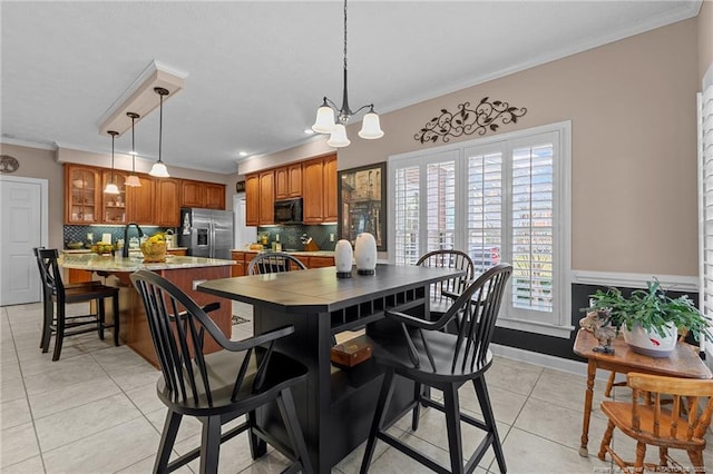 kitchen featuring black microwave, a notable chandelier, stainless steel refrigerator with ice dispenser, brown cabinetry, and crown molding