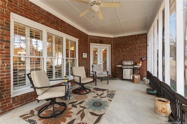 sunroom / solarium with a healthy amount of sunlight, ceiling fan, and french doors