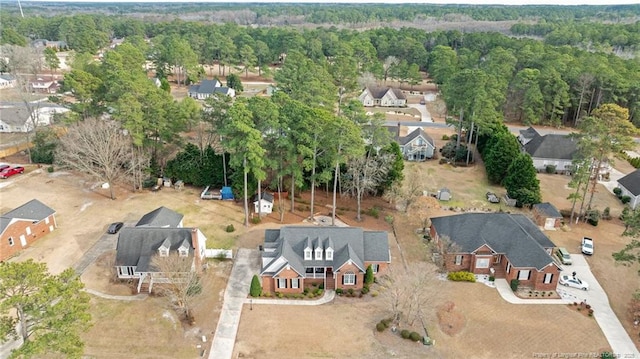 drone / aerial view featuring a residential view and a view of trees