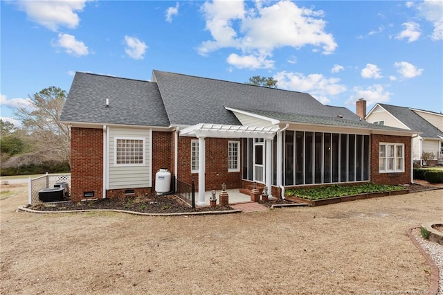 rear view of house featuring central AC, brick siding, a sunroom, crawl space, and a pergola