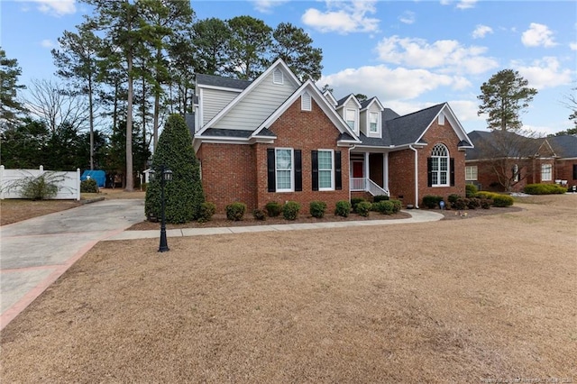 view of front of home with brick siding and fence