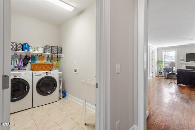 washroom with tile patterned flooring, laundry area, baseboards, and washer and clothes dryer