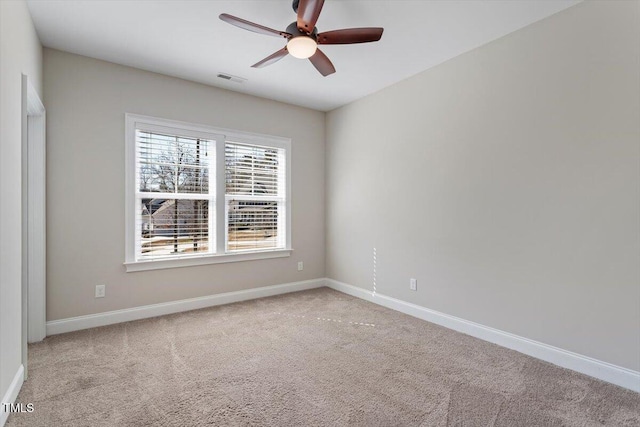 carpeted empty room featuring visible vents, baseboards, and ceiling fan