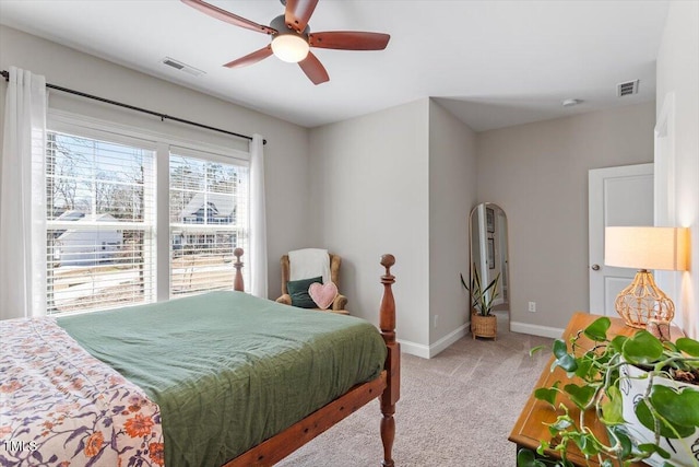 bedroom with light carpet, visible vents, a ceiling fan, and baseboards