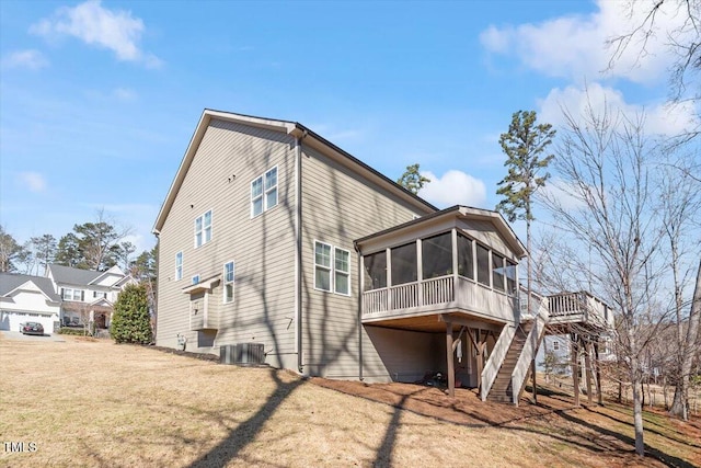 view of side of home featuring stairs, a yard, central AC unit, and a sunroom