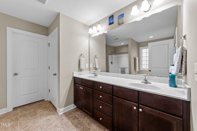 bathroom with tile patterned flooring, baseboards, double vanity, a stall shower, and a sink