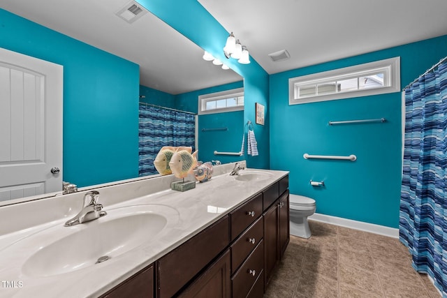 bathroom featuring a sink, visible vents, baseboards, and toilet