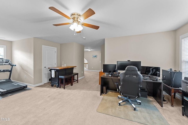 home office featuring visible vents, baseboards, light colored carpet, and ceiling fan