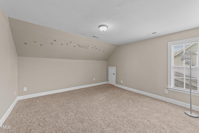 bonus room with baseboards, lofted ceiling, visible vents, and carpet flooring