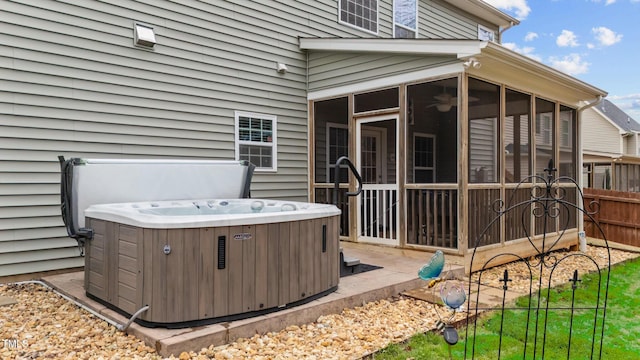 view of patio featuring a sunroom, fence, central AC, and a hot tub