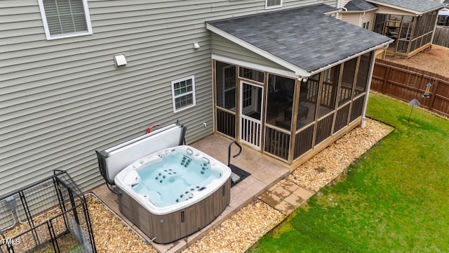 exterior space with a hot tub, fence, a patio, and a sunroom