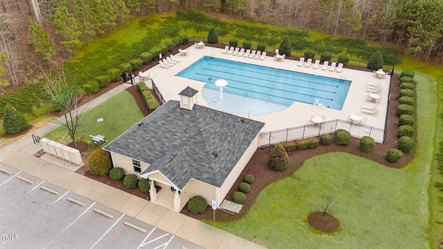 pool with a yard, a patio, and fence