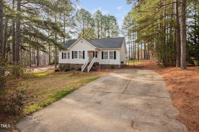 view of front facade featuring roof with shingles, driveway, and crawl space