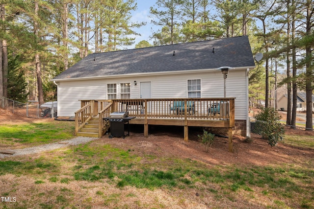 back of property featuring a gate, roof with shingles, a deck, and fence