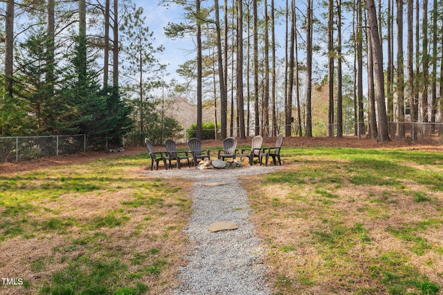 view of yard with fence and an outdoor fire pit