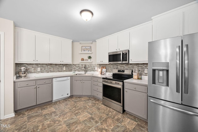 kitchen featuring a sink, light countertops, backsplash, and stainless steel appliances