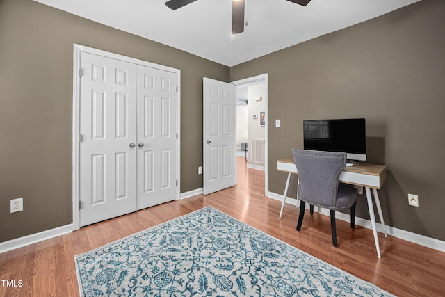 office space featuring wood finished floors, a ceiling fan, and baseboards