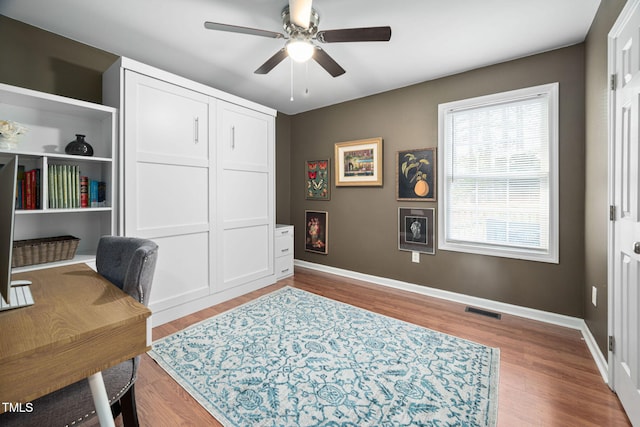 office with wood finished floors, baseboards, visible vents, and ceiling fan