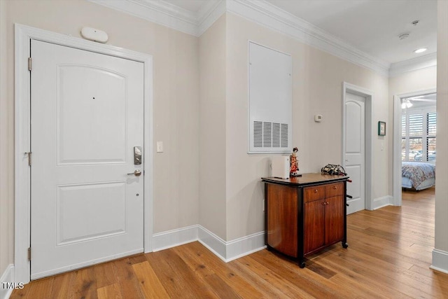 entrance foyer with baseboards, light wood-style flooring, and crown molding