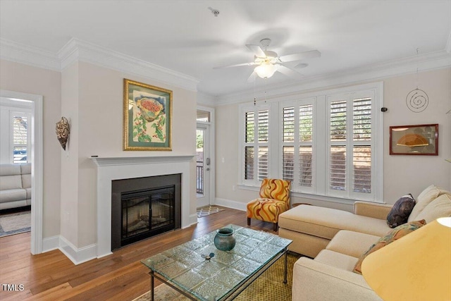 living room featuring a healthy amount of sunlight, wood finished floors, and ornamental molding