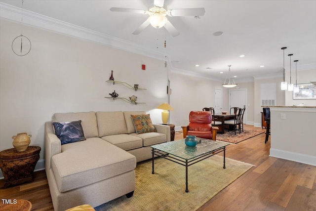 living room featuring ornamental molding, recessed lighting, light wood finished floors, baseboards, and ceiling fan