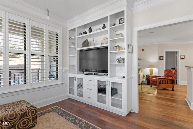 interior space with crown molding, baseboards, and wood finished floors