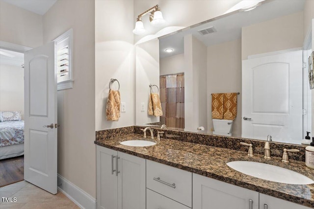 bathroom featuring a sink, visible vents, baseboards, and toilet