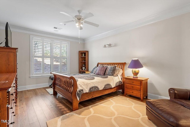 bedroom featuring visible vents, crown molding, baseboards, and hardwood / wood-style floors