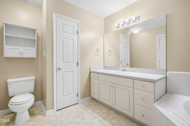 full bathroom with baseboards, toilet, tile patterned floors, a garden tub, and vanity