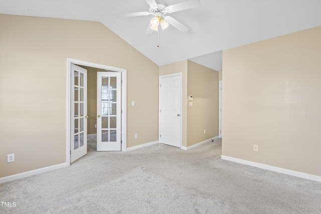 carpeted spare room featuring french doors, vaulted ceiling, baseboards, and ceiling fan