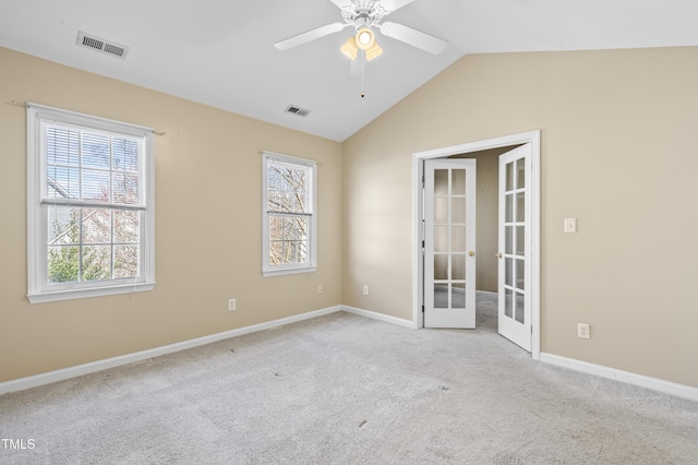 unfurnished room with carpet floors, lofted ceiling, french doors, and visible vents