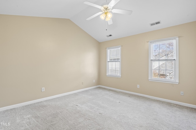 unfurnished room with light carpet, visible vents, vaulted ceiling, and a ceiling fan