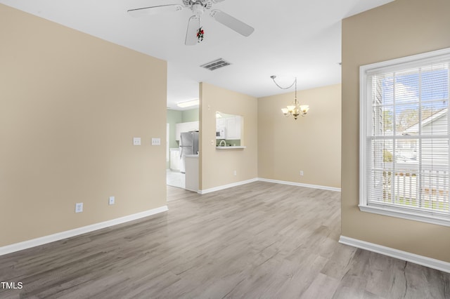 empty room with light wood-type flooring, visible vents, plenty of natural light, and baseboards