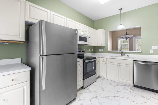 kitchen with marble finish floor, stainless steel appliances, a sink, and light countertops