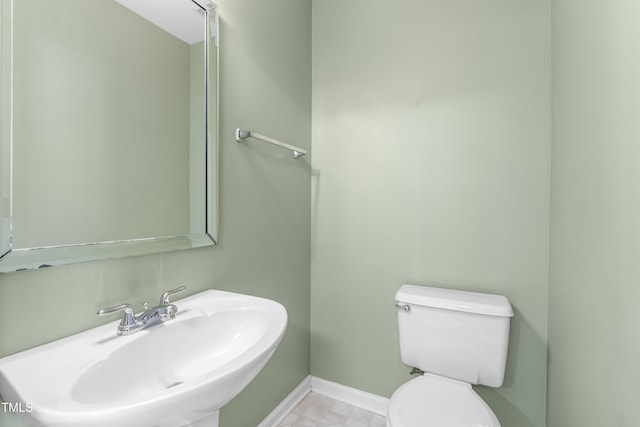 bathroom featuring a sink, toilet, and baseboards