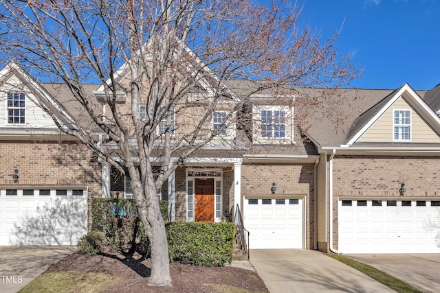 view of property featuring driveway, a shingled roof, a garage, and brick siding