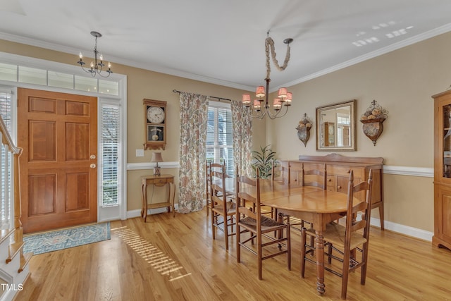 dining area with light wood-style floors, baseboards, a chandelier, and ornamental molding