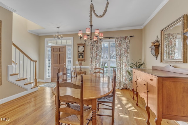 dining area with a chandelier, crown molding, light wood-style floors, and stairs