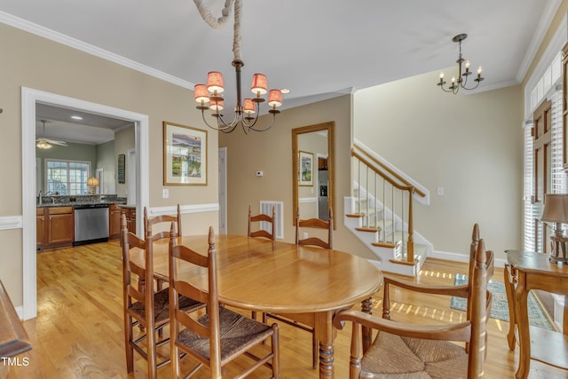 dining space featuring light wood finished floors, baseboards, stairway, ornamental molding, and ceiling fan with notable chandelier