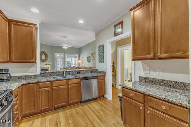 kitchen with stainless steel appliances, brown cabinets, visible vents, and a sink