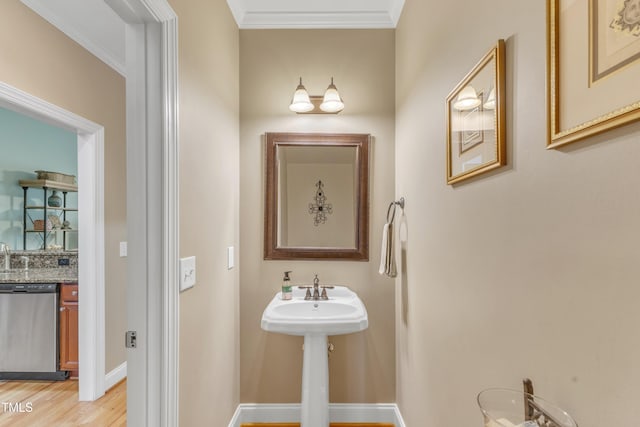 bathroom featuring baseboards, ornamental molding, and wood finished floors