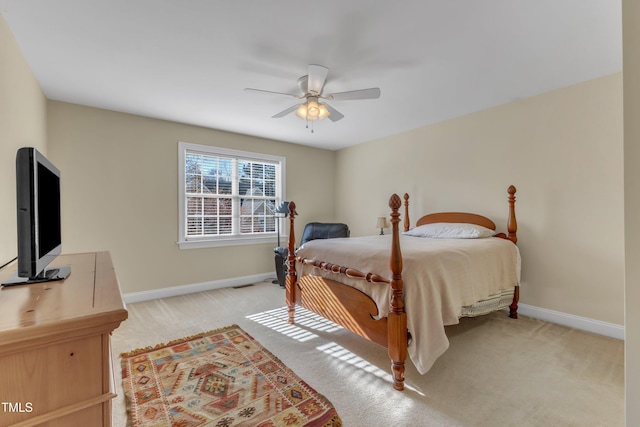 bedroom with light carpet, a ceiling fan, and baseboards