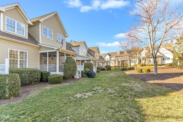 view of yard featuring a residential view and a sunroom