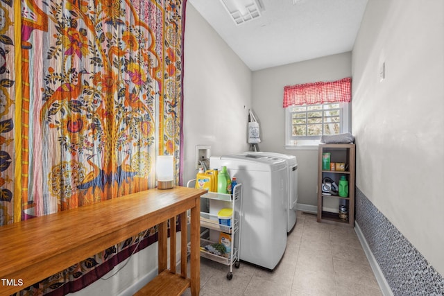 laundry room with tile patterned flooring, laundry area, baseboards, and separate washer and dryer